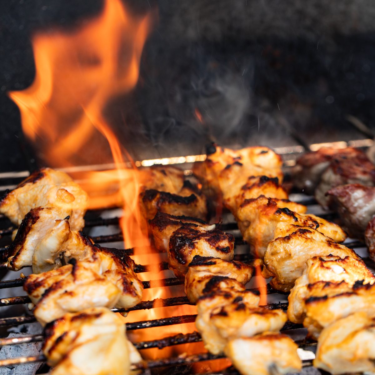 Evercoal charcoal burning under chicken skewers on a barbecue